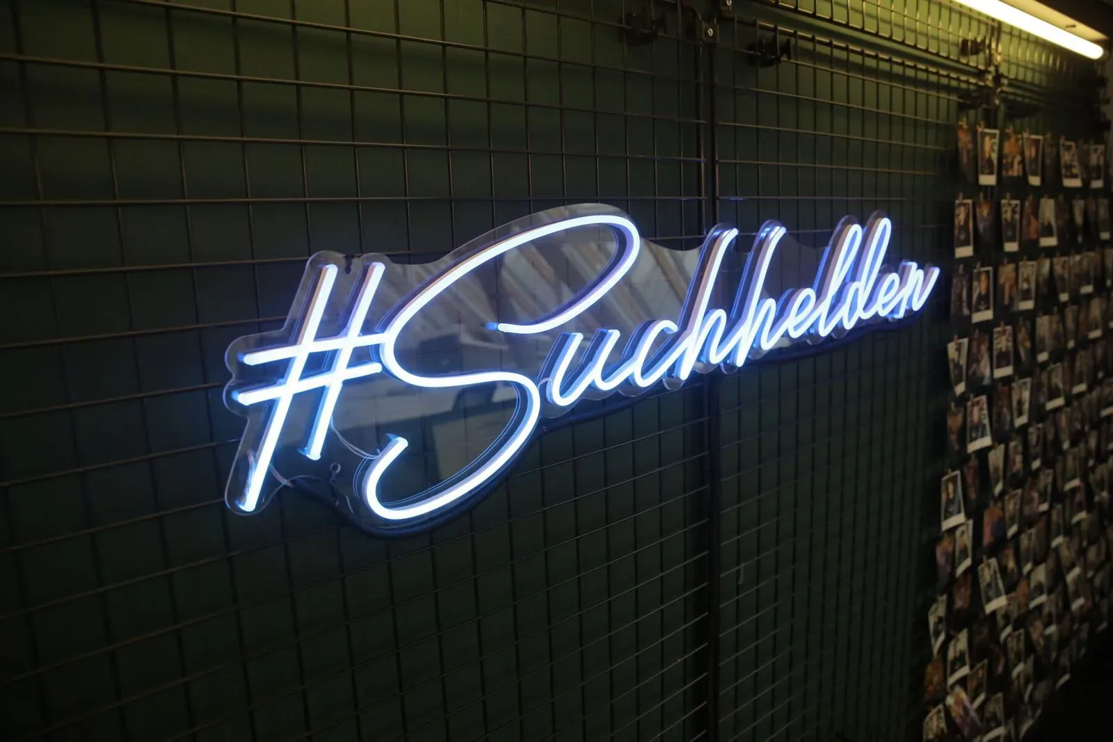 Neonschriftzug „#Suchhelden“ neben der Polaroid-Wand im Suchhelden-Büro in Osnabrück Neonschriftzug „#Suchhelden“ neben der Polaroid-Wand im Suchhelden-Büro in Osnabrück