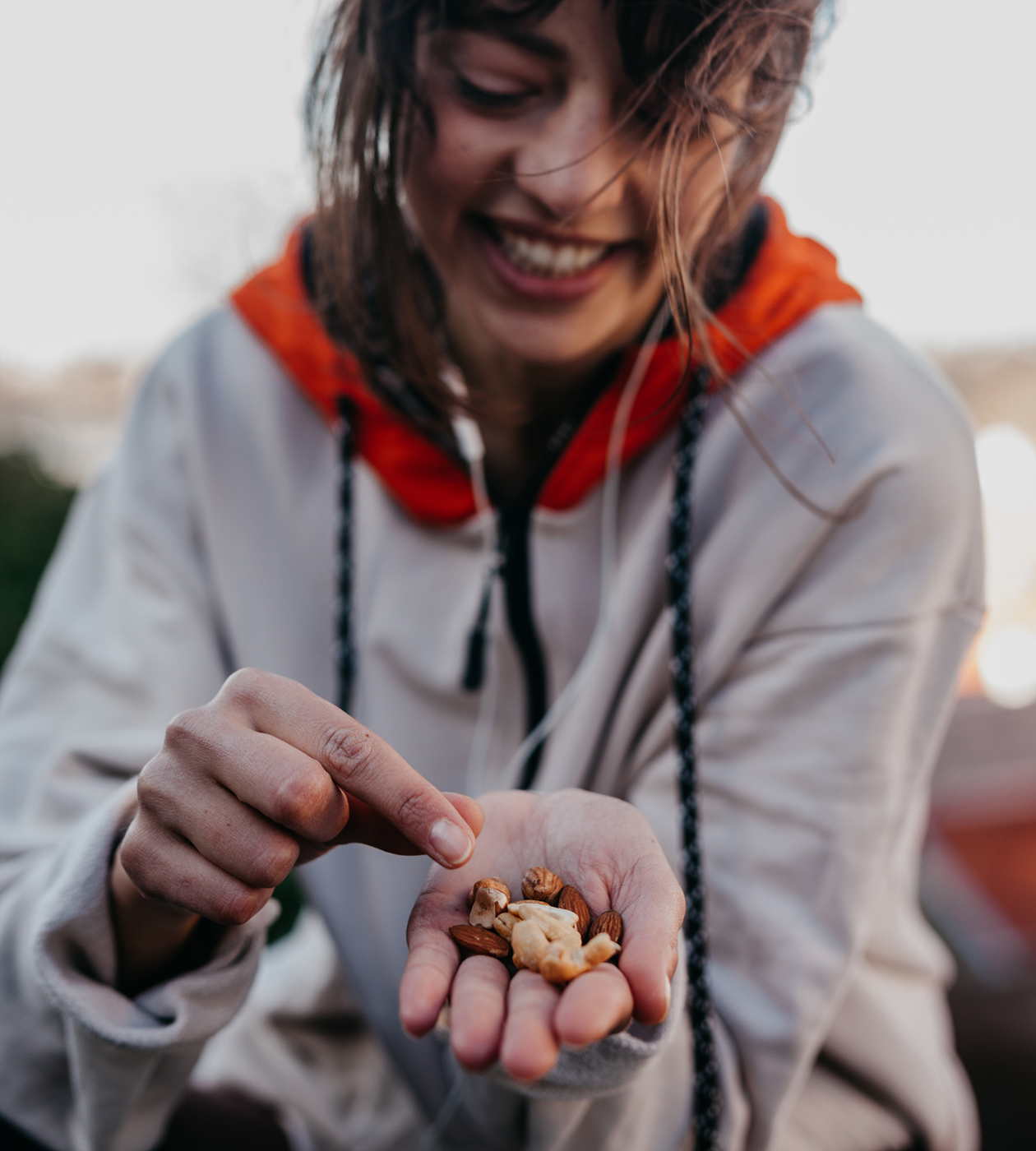 Eine Frau haelt eine kleine Menge Nuesse in ihrer Hand